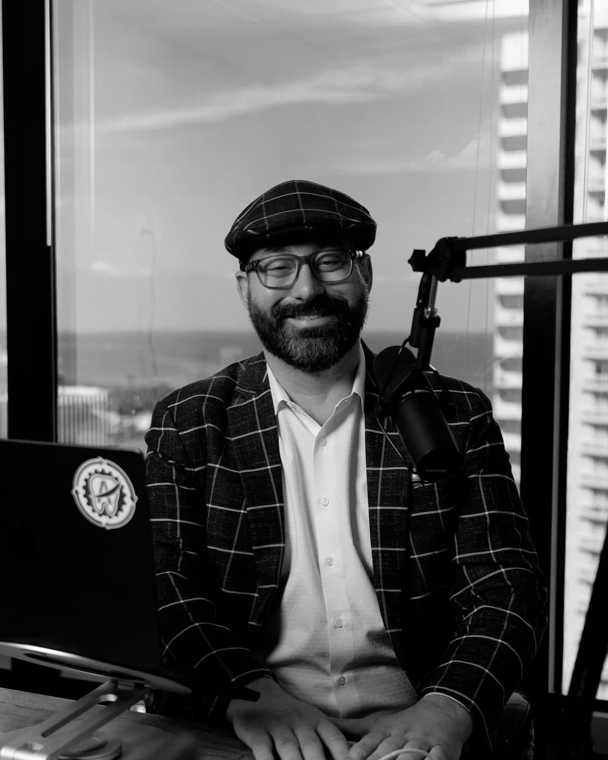 Paul W. Swaney III in a black and white studio portrait at a microphone.